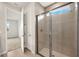 Modern bathroom showing glass shower and open door to carpeted bedroom at 17800 Solstice Ave, Venice, FL 34293