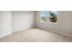 Neutral bedroom with carpet and two windows looking out on green landscaping and a pond at 17800 Solstice Ave, Venice, FL 34293