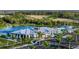 Aerial view of the clubhouse with a pool, surrounded by lush landscaping and mature trees at 17800 Solstice Ave, Venice, FL 34293