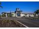 Community clubhouse featuring modern architectural design, lush landscaping, and ample parking at 17800 Solstice Ave, Venice, FL 34293