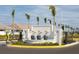 Gated community entrance featuring a decorative fountain, palm trees, and a secure entry system at 17800 Solstice Ave, Venice, FL 34293