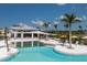 Resort-style community pool with lounge chairs, umbrellas, and a modern clubhouse nearby at 17800 Solstice Ave, Venice, FL 34293