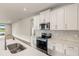 Open kitchen features stainless steel appliances, an island with a sink, and a view of the outdoors at 17800 Solstice Ave, Venice, FL 34293