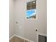 Bright laundry room featuring white walls, tile flooring and a window for natural light at 17800 Solstice Ave, Venice, FL 34293