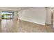 Bright living room with wood-look tile floors and sliding glass doors to a patio overlooking a lake at 17800 Solstice Ave, Venice, FL 34293