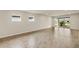 Bright and spacious living room with wood-look tile flooring and sliding glass doors to the backyard at 17800 Solstice Ave, Venice, FL 34293