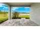 A covered patio featuring stone flooring and a tranquil view of a pond and landscaped yard at 17800 Solstice Ave, Venice, FL 34293