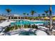 Resort-style pool featuring a hot tub, covered lounge area, lounge chairs, and tropical landscaping at 17800 Solstice Ave, Venice, FL 34293