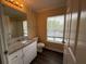 Well-lit bathroom featuring a granite vanity, window and shower with tub at 18267 Bridle Club Dr, Tampa, FL 33647