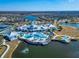 Aerial shot of a community clubhouse with a pool, lakes, and surrounding residential area at 18636 Sailors Delight Pass, Land O Lakes, FL 34638