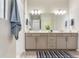 Bathroom featuring a double sink vanity, large mirror and modern lighting at 18636 Sailors Delight Pass, Land O Lakes, FL 34638