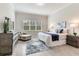 Brightly lit bedroom featuring a window view and wood-look tile flooring with a blue rug at 18636 Sailors Delight Pass, Land O Lakes, FL 34638