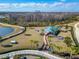 Aerial view of community dog park featuring play structures, covered seating, sidewalks and decorative palms at 18636 Sailors Delight Pass, Land O Lakes, FL 34638