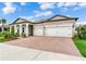 Charming exterior featuring a two-car garage, covered front porch with seating, and well-manicured landscaping at 18636 Sailors Delight Pass, Land O Lakes, FL 34638