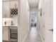 Stylish hallway featuring custom cabinetry with a wine rack and a wine cooler, blending functionality with luxury at 18636 Sailors Delight Pass, Land O Lakes, FL 34638
