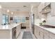 Bright kitchen boasts stainless appliances, white cabinets, modern countertops, and an island overlooking the dining area at 18636 Sailors Delight Pass, Land O Lakes, FL 34638