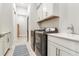 Laundry room with modern washer and dryer, sink, white cabinets, and tile floor at 18636 Sailors Delight Pass, Land O Lakes, FL 34638