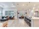 Open-concept living space shows the kitchen, dining area, and living room with wood-look tile flooring at 18636 Sailors Delight Pass, Land O Lakes, FL 34638