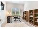 Bright office with a large window, an adjustable desk, and wooden bookshelves, perfect for a productive workspace at 18636 Sailors Delight Pass, Land O Lakes, FL 34638