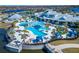 Aerial view of a stunning community pool area, featuring multiple pools, lounging areas, and lush landscaping at 18636 Sailors Delight Pass, Land O Lakes, FL 34638