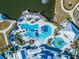 Aerial view of community pools, featuring multiple pools, lounging areas, and landscaping around a pond at 18636 Sailors Delight Pass, Land O Lakes, FL 34638
