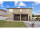 View of the home's back exterior and a screened patio, perfect for outdoor relaxation and entertainment at 19214 Early Violet Ne Dr, Tampa, FL 33647