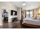 Bedroom featuring hardwood flooring, a large TV, and a walk-in closet at 19214 Early Violet Ne Dr, Tampa, FL 33647