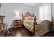 Bedroom featuring hardwood floors, a decorative bed, and a side table with a lamp at 19214 Early Violet Ne Dr, Tampa, FL 33647