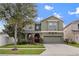 Charming two-story home featuring a well-manicured lawn and a two-car garage, providing curb appeal at 19214 Early Violet Ne Dr, Tampa, FL 33647