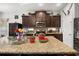 Kitchen featuring granite countertops, stainless steel appliances, dark wood cabinets, and a mosaic tile backsplash at 19214 Early Violet Ne Dr, Tampa, FL 33647