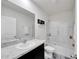 Bright bathroom featuring a shower-tub combo with glass doors and a granite vanity at 1967 Hovenweep Rd, Wesley Chapel, FL 33543