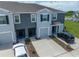 View of the townhome exterior with gray paint, driveway, and attached garage at 1967 Hovenweep Rd, Wesley Chapel, FL 33543