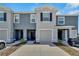 Gray two-story townhome with a one-car garage and a well-kept lawn, providing a welcoming curb appeal at 1967 Hovenweep Rd, Wesley Chapel, FL 33543