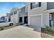 Townhome exterior shows the driveway leading to the garage, with neat landscaping and modern architectural design at 1967 Hovenweep Rd, Wesley Chapel, FL 33543