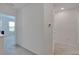 Clean hallway with neutral carpet and white walls leads to a bedroom area with view at 1967 Hovenweep Rd, Wesley Chapel, FL 33543