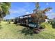 Spacious backyard features a screened-in pool area with mature trees and lush landscaping at 20647 Ovid Ln, Venice, FL 34293