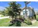 Charming home exterior with lush landscaping, a well-maintained lawn, and a stone facade at 20647 Ovid Ln, Venice, FL 34293