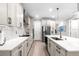 Bright kitchen with marble countertops, stainless appliances, and modern globe chandelier at 20647 Ovid Ln, Venice, FL 34293