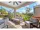 Screened-in patio with comfortable seating, perfect for relaxation and enjoying the outdoor view at 20647 Ovid Ln, Venice, FL 34293