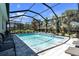 Sparkling pool area enclosed with screen, surrounded by comfortable seating and lush landscaping at 20647 Ovid Ln, Venice, FL 34293