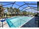 Inviting pool area with lounge chairs, surrounded by lush landscaping and a screened enclosure at 20647 Ovid Ln, Venice, FL 34293