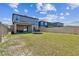 Large backyard with grass and a privacy fence. Blue skies overhead at 22287 Storybook Cabin Way, Land O Lakes, FL 34637