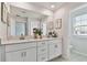 Bright bathroom with a double sink vanity, quartz countertop, and large mirror at 22287 Storybook Cabin Way, Land O Lakes, FL 34637