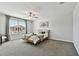 Bright bedroom with a modern ceiling fan, large window, soft carpet, and neutral decor offers a tranquil retreat at 22287 Storybook Cabin Way, Land O Lakes, FL 34637