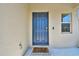Stylish blue front door, modern lock, and welcome mat on a bright, sunny day at 22287 Storybook Cabin Way, Land O Lakes, FL 34637