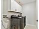 Laundry room featuring a modern washer and dryer, complemented by pristine white cabinets for storage and organization at 22287 Storybook Cabin Way, Land O Lakes, FL 34637