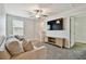 Bright living room with a comfortable sofa, TV, carpet, window with blinds, and a modern ceiling fan at 22287 Storybook Cabin Way, Land O Lakes, FL 34637
