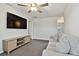 Living room features a comfortable sofa, TV, carpet, and a modern ceiling fan, creating a welcoming atmosphere at 22287 Storybook Cabin Way, Land O Lakes, FL 34637