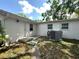 Exterior view of the home's backyard, complete with air conditioning unit, entry door, and windows at 2315 Carroll Pl, Tampa, FL 33612