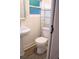 This bathroom features a pedestal sink, modern toilet, shelving unit, and tile flooring at 2315 Carroll Pl, Tampa, FL 33612